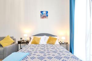 una camera da letto con un letto con cuscini gialli e un divano di Sea Nest Studio in NorD10 By Alezzi a Mamaia Altre 38 foto