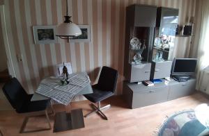 Una sala de estar con una mesa y sillas y un televisor. en Ferienwohnungen Eckstein, en Bernkastel-Kues