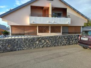 a house with a stone wall in front of it at Bel Appartement avec terrasse proche des plages in Saint-Gilles les Bains