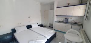 Habitación pequeña con cama y cocina en Toula's Apartments, en Platamonas