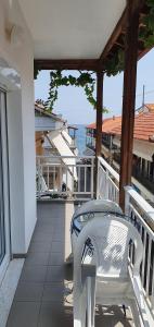 una silla blanca sentada en un balcón con vistas al océano en Toula's Apartments, en Platamonas