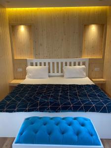 a bedroom with a bed with a blue comforter at BELLE VUE COTTAGES in Kūd