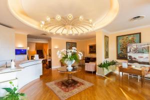 una gran sala de estar con un jarrón de flores sobre una mesa en Hotel Milton Rimini, en Rímini