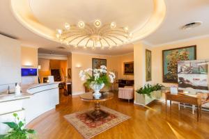 a large living room with a vase of flowers on a table at Hotel Milton Rimini in Rimini