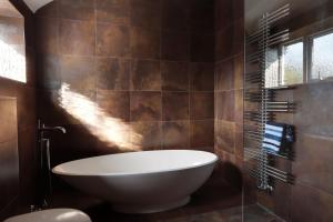 a bathroom with a large tub and a toilet at Bretton House Farm Retreat in Chester