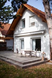uma casa branca com uma mesa e cadeiras num deque em Silver Willow Luxury Apartment em Sopron