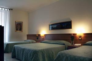 una camera d'albergo con tre letti e due lampade di Emanuela B&B a Roma