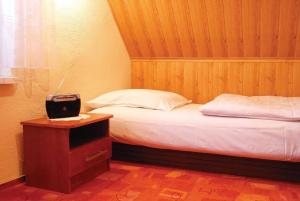 sypialnia z 2 łóżkami i stołem z zegarem w obiekcie Santoczno Santohaus dom wakacyjny nr 5 w mieście Santoczno