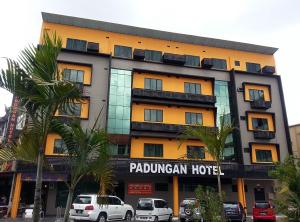 Padungan Hotel في كوتشينغ: فندق فيه سيارات تقف امامه