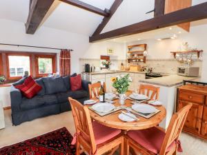 a kitchen and living room with a wooden table and chairs at 1 Yew Tree Cottages in Penrith
