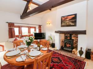 a dining room with a table and a fireplace at 1 Yew Tree Cottages in Penrith