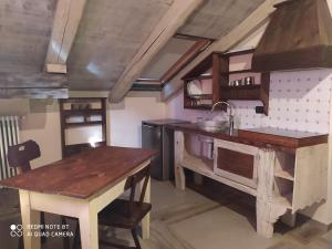 a kitchen with wooden counters and a table in it at La Via' in Cavour