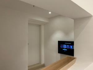 una TV sul muro in una stanza bianca di Casa Vacanze Portopalo.66 a Portopalo
