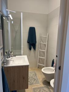 a bathroom with a sink and a toilet and a mirror at Appartamento Portopalo 1966 in Portopalo