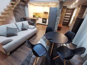a living room with a couch and a table and chairs at Goldcentral Apartments - Stylish Apartments - Wine Tasting Access in Budapest