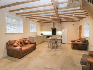 a living room with two leather couches and a table at Winnie's Stable in York