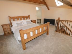a bedroom with a wooden bed and a staircase at Winnie's Stable in York
