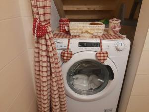 a washing machine with red and white curtains on it at APPARTAMENTO GIRASOLE in Carano