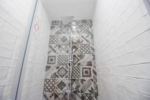 a shower in a bathroom with a tile wall at Dandelion hostel in Zadar