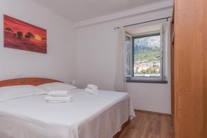 a white bed in a room with a window at Apartment Alen in Makarska