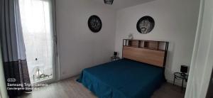 サン・シプリアンにあるRESIDENCE DE LA MER - Appartement 2 chambres très spacieux A 2 pas du Port et de la Plage - Clim - parkingのベッドルーム1室(ベッド1台、壁に2つの時計付)