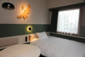 a hotel room with a bed and a window at HOTEL GLOBAL VIEW Niigata in Niigata