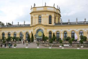 a large yellow building with people walking in front of it at Lovely Central Located- Train, Restaurants & Spa in Kassel