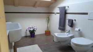 a bathroom with a toilet and a sink at APPARTAMENTO GIRASOLE in Carano +14 photos