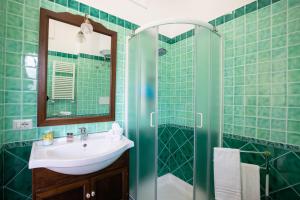 a green tiled bathroom with a sink and a shower at City Home in Sorrento with Balcony and view in Sorrento