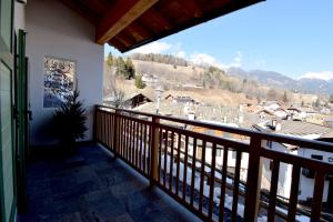a balcony with a view of a town and mountains at APPARTAMENTO GIRASOLE in Carano