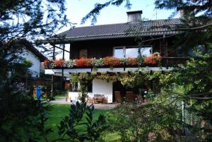 ein Haus mit Blumen auf der Seite in der Unterkunft 2-Zimmer DG-Apartment mit eigener Sauna in Oberhaching