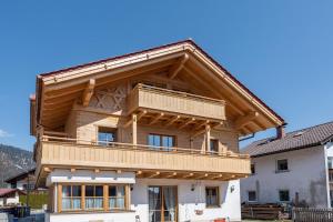 a wooden house with a balcony on top of it at Ferienwohnung Susi im Neubau in Farchant
