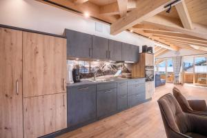 eine Küche mit grauen Schränken und Holzwänden in der Unterkunft Ferienwohnung Susi im Neubau in Farchant