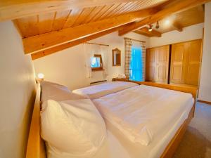 レーゲンにあるFerienhaus Regentの木製天井の客室で、白い大型ベッド1台が備わります。