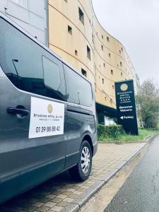 a van parked on a street next to a building at Standing Hotel Suites by Actisource in Roissy-en-France