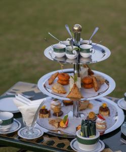 a three tiered plate of food on a table at Heritance Tea Factory in Nuwara Eliya