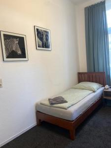 a bed in a room with two pictures on the wall at Apartment KLASSIKO in Bremerhaven