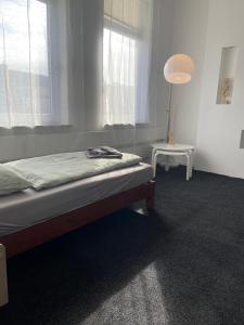 a bedroom with a bed and a lamp and a window at Apartment KLASSIKO in Bremerhaven