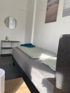 a bed sitting in a room with a table at Apartment KLASSIKO in Bremerhaven