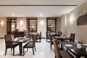 a restaurant with black tables and chairs and windows at Eurostars das Artes in Porto +48 photos