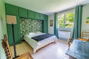 Dormitorio verde con cama y ventana en Bons Baisers du Touquet - Villa Caracole, en Le Touquet-Paris-Plage