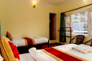 a room with two beds and a window at Hotel Homeland and Restaurant in Pokhara