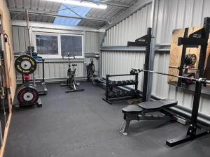 een fitnessruimte met gewichten en apparatuur in een garage bij Highland Holiday Cottages in Newtonmore