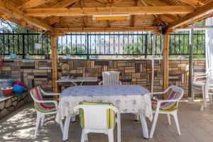 a patio with a table and chairs and a stone wall at Aigli House in Skala Kallirakhis