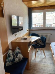 a small room with a desk and two chairs at Hotel Garni Schmieder’s Ochsen in Seelbach