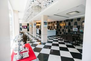 un ristorante con pavimento a scacchi in bianco e nero di Best Western Royal Buriram a Buriram