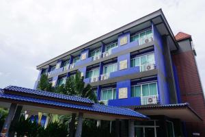 ein blaues Gebäude mit Balkonen und Palmen in der Unterkunft Best Western Royal Buriram in Buriram