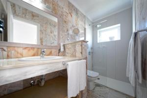 a bathroom with a sink and a toilet and a mirror at Vista Bonita - Gay and Lesbian Only Resort in Maspalomas +32 photos