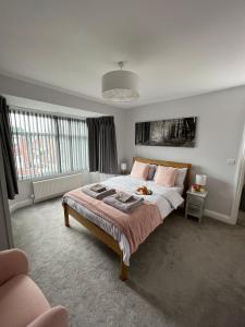 um quarto com uma cama grande e almofadas cor-de-rosa em The Wootton House em Doncaster