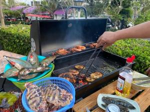 a person is cooking food on a grill at Villa Biển - Oceanami Resort Long Hải in Long Hai